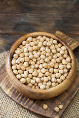 Chickpeas in a wooden bowl on a wooden table. Rustic style