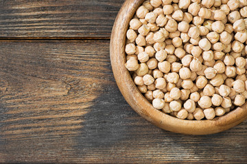Chickpeas in a wooden bowl on a wooden table. Rustic style