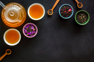 Tea ceremony frame with leaves and brew on black background top view copyspace