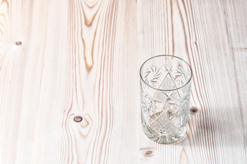 Empty crystal glass on a wooden table. Close up