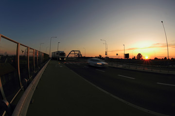 Zachód słońca nad autostradą, samochody, most.