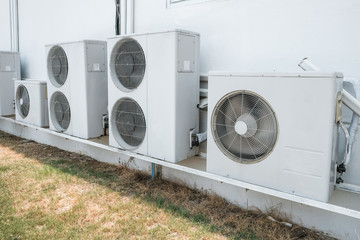 Row of air compressors outside the industry building wall. Air compressors installed in the...