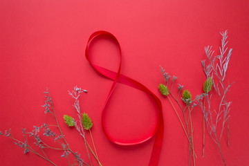 Satin red ribbon in the form of 8 on a red background