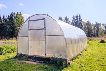 Greenhouse. Bright greenhouse in the garden. Indoor stationary greenhouse