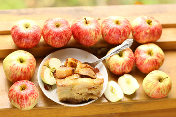 pieces of fresh baked apple pie among raw apples country style still life