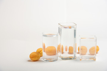 Foods distorted through liquid and glass on white background.