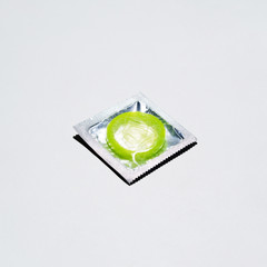 High angle green condom on white background