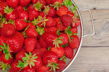 Red ripe strawberries on wooden table close up