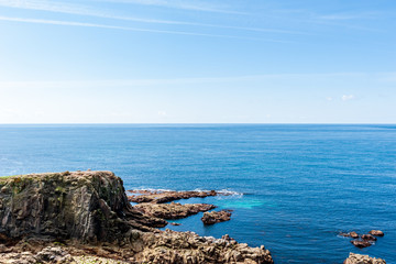 Rocky shoreline at Land’s End on a clear and sunny day in Land’s End, UK.