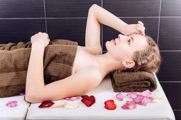 Obraz na płótnie Canvas woman relaxing on a massage table in a dark room spa salon