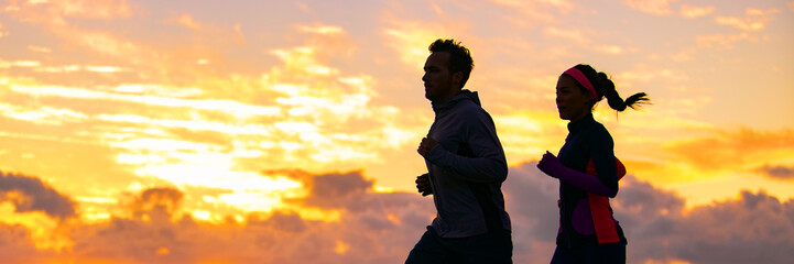 Run fit couple sport banner panorama of runners friends woman and man training cardio together running on outdoor race at sunset panoramic background. Silhouettes of two athletes working out. - Powered by Adobe