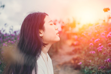 beautiful Asian girl gentle breathing in the flower field sunset beauty moment scene