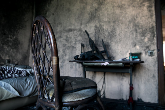 Burned interiors of industrial or residential building. Fire consequences concept. burnt chair and bed