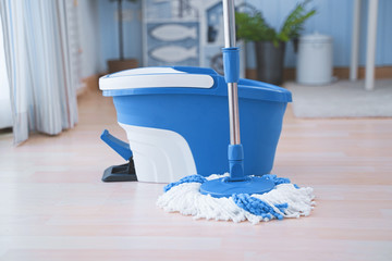 Floor cleaning with mob and bucket. Cleaning floor in the room.
