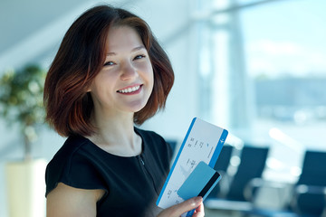 Business woman with tickets and credit card waiting for departure in airport