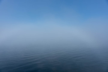 Aufsteigender Nebel über dem See mit ersten Sonnenstrahlen
