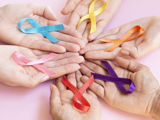 Close-up hands holding colorful awareness ribbons
