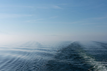 Aufsteigender Nebel über dem See mit ersten Sonnenstrahlen