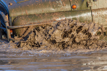 SUV wheel stalled in mud and water