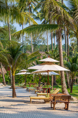 Sun umbrella and beach chairs on tropical coastline for holidays and relaxation , Thailand. Travel and nature concept