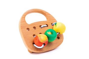 Photo of a wooden wooden toy with lace and beads of different colors on wheels  of beech. Toy made of wood  on a white isolated background.A toy for entertaining children and resting parents