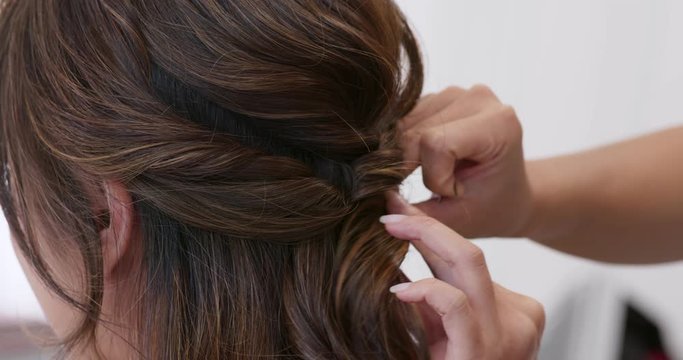 Make up artist make a hairstyle for bride in salon
