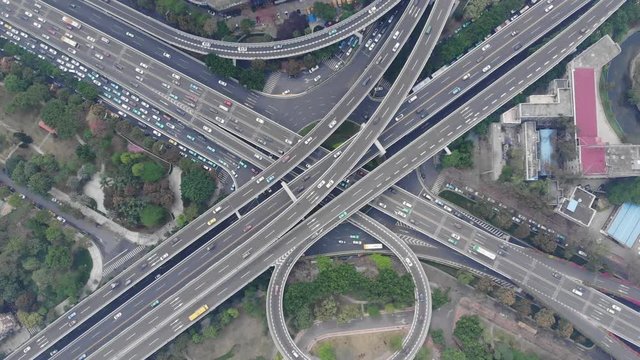 Aerial view of large junction within city area, many overpasses stacked one above another, cross main way Lively traffic on roads, convenient transport network at modern district of Chinese big city
