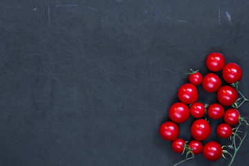 Red fresh tomatoes cherry on black background