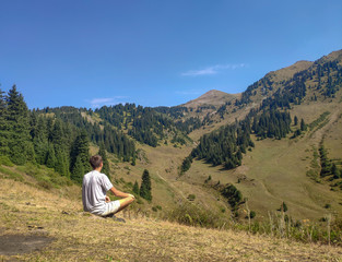 Trans-Ili Alatau mountain range of the Tien Shan system in Kazakhstan near the city of Almaty. Rocky peaks covered with snow and glaciers in the middle of summer under clouds