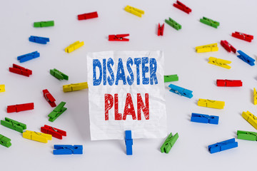 Text sign showing Disaster Plan. Business photo showcasing Respond to Emergency Preparedness Survival and First Aid Kit Colored clothespin papers empty reminder white floor background office
