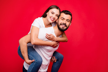 Obraz premium Photo of cheerful cute nice attractive trendy piggyback beautiful handsome couple wearing jeans denim while isolated with red background