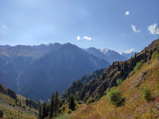 Trans-Ili Alatau mountain range of the Tien Shan system in Kazakhstan near the city of Almaty. Rocky peaks covered with snow and glaciers in the middle of summer under clouds