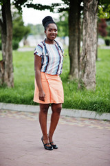 Young african american female doctor hold white coat on hand with a stethoscope posed outdoor.