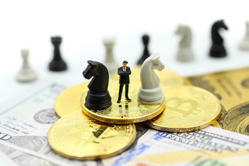 Miniature people : business team strategy training with chess,target,dollars,bitcoins,decision and competition concept.