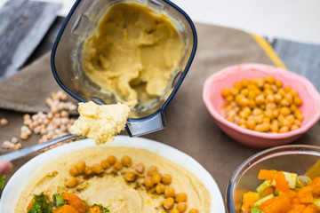 Original homemade arabic chickpea hummus with olive oil and cumin. Creamy dip paste. Blender or food processor with made hummus paste.