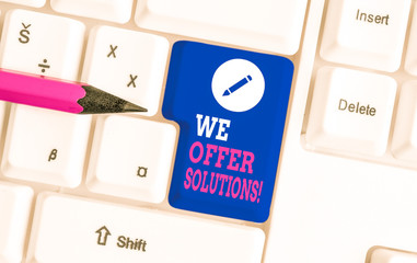 Writing note showing We Offer Solutions. Business concept for way to solve problem or deal with difficult situation White pc keyboard with note paper above the white background