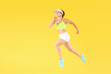 Fototapeta na wymiar Running female tennis player on color background