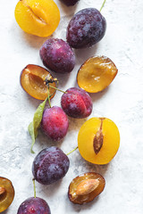 Many fresh plums on light grey background isolated