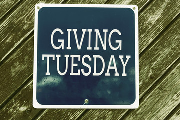 Handwriting text writing Giving Tuesday. Conceptual photo international day of charitable giving Hashtag activism Empty blue board with copy space above wooden background