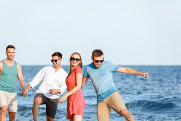 Happy friends on sea beach at resort