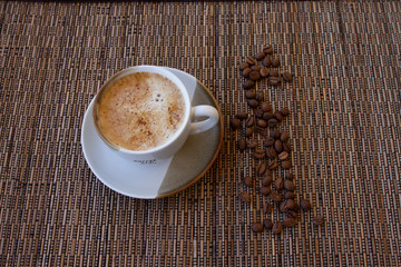 cup of coffee coffee beans cinnamon on a brown background