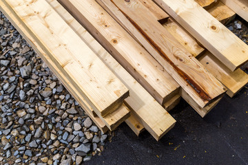 Stack of natural wooden boards on building site. Industrial timber for carpentry, building or repairing, lumber material for roofing construction.