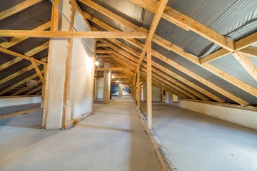 Attic of a building with wooden beams of a roof structure.