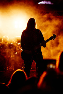 A heavy metal rock star playing guitar. Hard rock guitarist in concert.