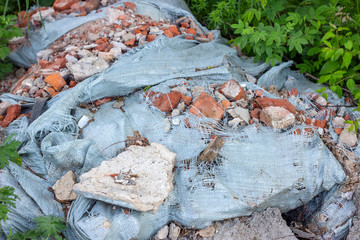 Сonstruction garbage, debris and waste rubble in a remote green area. Nature and soil pollution concept