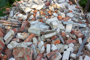 Сonstruction garbage, debris and waste rubble in a remote green area. Nature and soil pollution concept