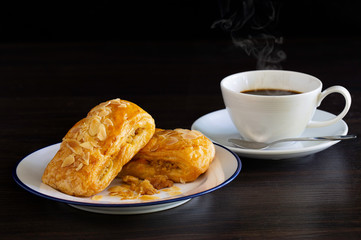 Chicken Pie sprinkle with dry pumpkin seed in white dish and black coffee in cup, all on dark wooden background