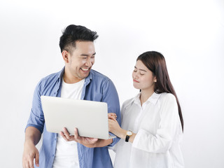 Happy Asian couple shopping online with holding credit card and laptop and sitting at home together, lifestyle concept.
