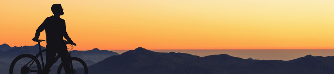 Cyclist in shorts and jersey on a modern carbon hardtail bike with an air suspension fork rides...