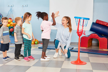 Fototapeta premium Kinder und Sportlehrerin machen High Five